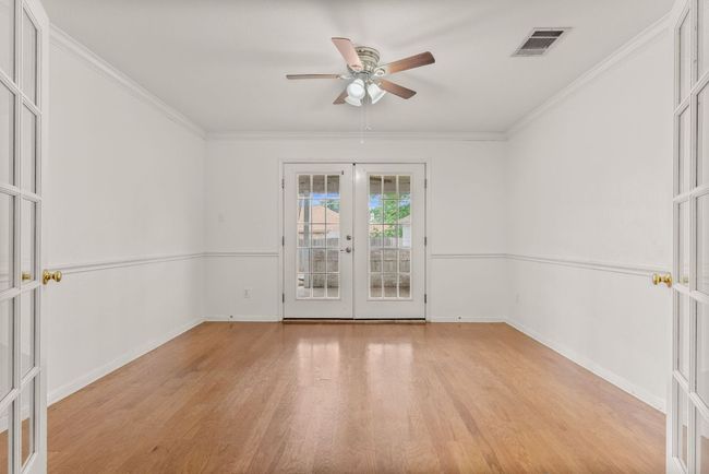 Empty room featuring ornamental molding, a ceiling fan, french doors, and light wood-style flooring | Image 11