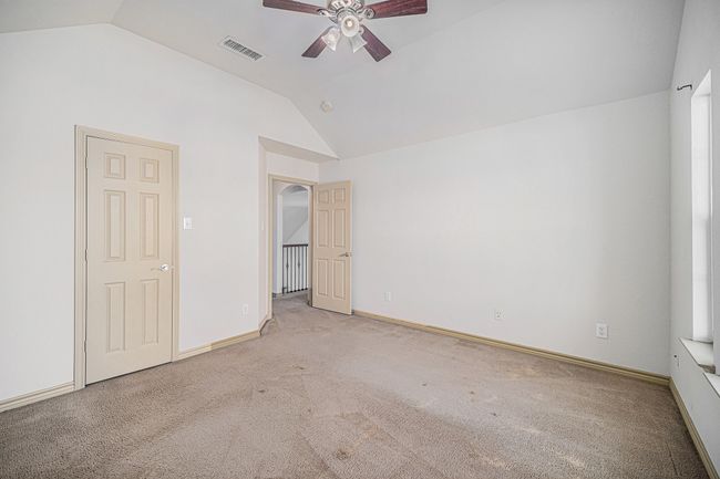 Unfurnished bedroom with vaulted ceiling, carpet, baseboards, and a ceiling fan | Image 18