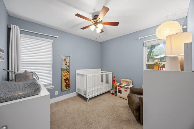 Bedroom with carpet, a crib, and a ceiling fan | Image 14