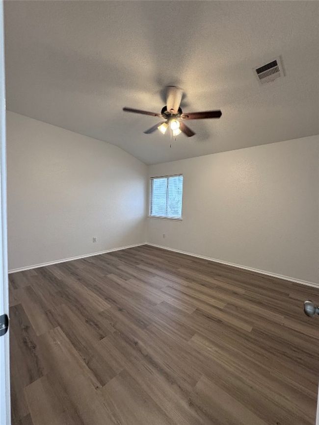 Empty room featuring a ceiling fan, dark wood-style flooring, and a textured ceiling | Image 24