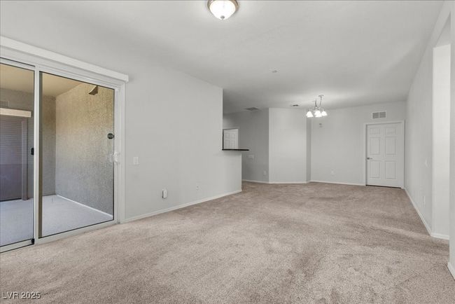 Unfurnished living room with carpet flooring and a chandelier | Image 18