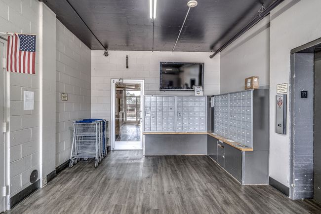 The mail room is situated just beyond the main lobby, with convenient access to both the elevators and the rear parking lot. To make residents' lives easier, carts are readily available to assist in transporting groceries and other shopping items. | Image 33