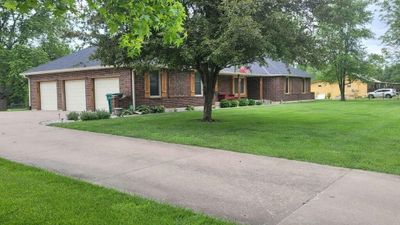 Ranch-style home featuring a garage and a front yard | Image 1