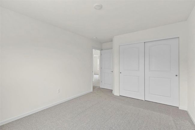 Unfurnished bedroom with light carpet and a closet | Image 10