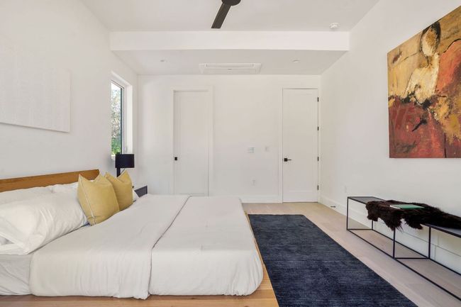 Bedroom with light wood-style floors, attic access, a ceiling fan, and baseboards | Image 37