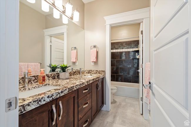 Bathroom featuring double vanity, toilet, shower / bathtub combination, and tile patterned flooring | Image 26