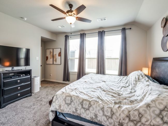 Carpeted bedroom with ceiling fan, baseboards, vaulted ceiling, and visible vents | Image 21