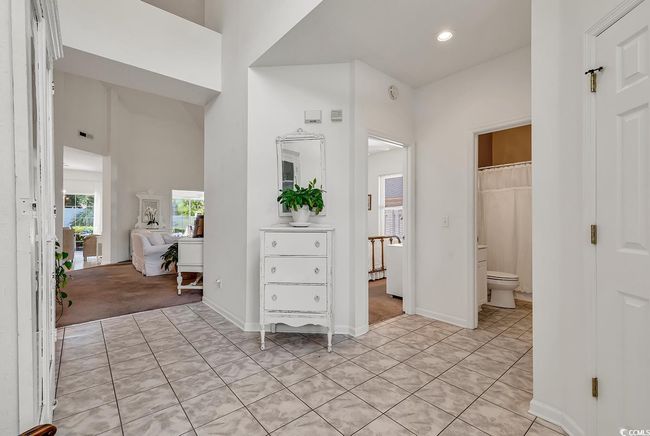 Bathroom featuring toilet, recessed lighting, tile patterned floors, baseboards, and a towering ceiling | Image 5