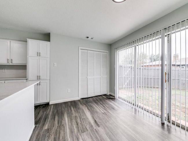Unfurnished dining area featuring baseboards and dark wood-style flooring | Image 9