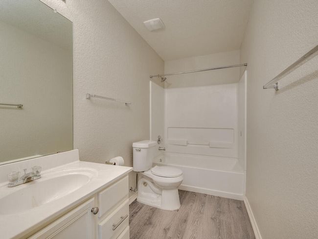 Second bathroom (shared by bedroom #2 and #3) features luxury vinyl wood-look flooring, spacious vanity, and shower/tub combo. | Image 22