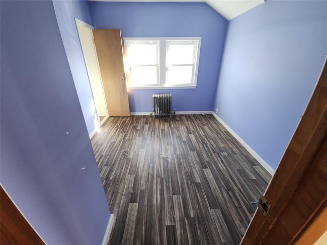 Bonus room with radiator heating unit, vaulted ceiling, and dark wood-type flooring | Image 9