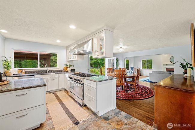 The chef’s kitchen is a showstopper, featuring granite counters, a premium gas range, and an oversized walk-in pantry—perfect for entertaining or farm-to-table cooking using your own fresh-picked produce from established fruit trees, berries, grapevines, and raised garden beds. | Image 5