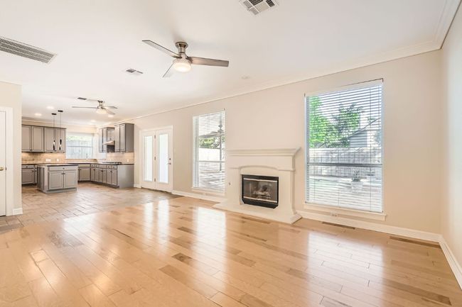 Unfurnished living room featuring crown molding, visible vents, a ceiling fan, and light wood finished floors | Image 9