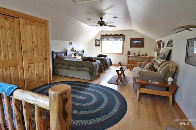 Bedroom featuring wood finished floors, lofted ceiling, and a ceiling fan | Image 14