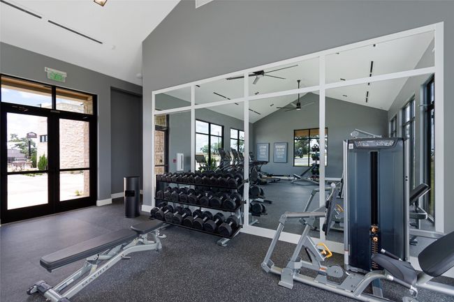 Exercise room with a ceiling fan, baseboards, and high vaulted ceiling | Image 40