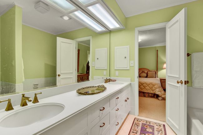 Ensuite bathroom with double vanity, tile patterned flooring, and ornamental molding | Image 29