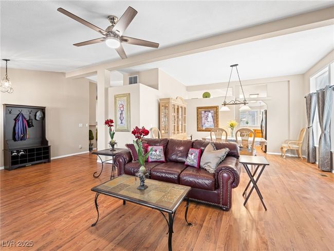Living area with ceiling fan, baseboards, light wood-style flooring, and vaulted ceiling with beams | Image 17