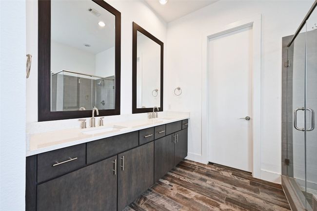 Bathroom with wood finished floors, a shower stall, double vanity, and recessed lighting | Image 14