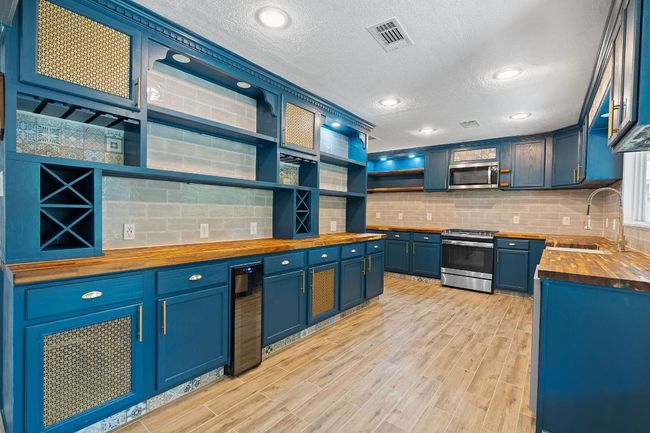 Grand kitchen expanded with custom built-ins. So many drawers. Butcher block countertops, wine storage and wine fridge. | Image 13