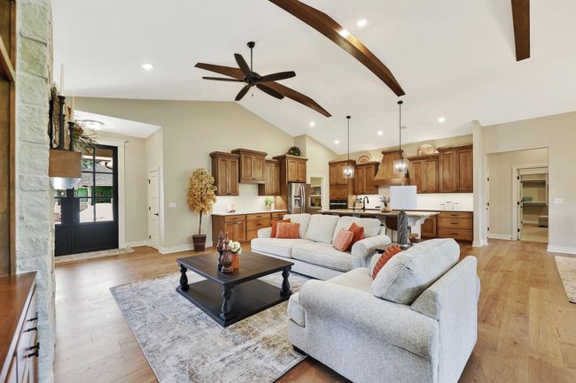 Living room with ceiling fan, sink, beam ceiling, light hardwood / wood-style flooring, and high vaulted ceiling | Image 7