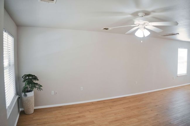 Empty room with ceiling fan and light wood-type flooring | Image 8