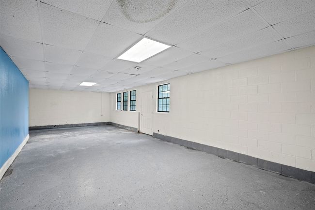 Unfurnished room with a paneled ceiling and concrete block wall | Image 25