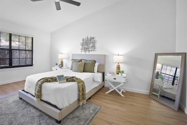 Bedroom with wood finished floors, vaulted ceiling, and a ceiling fan | Image 13