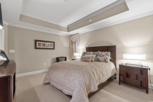 Carpeted bedroom featuring a raised ceiling and crown molding | Image 26