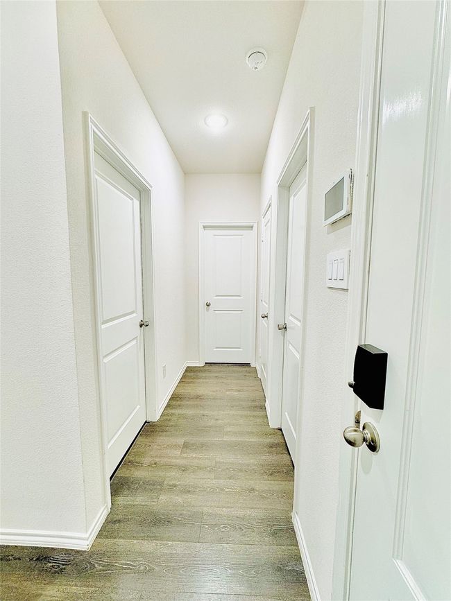 Hallway with light wood-style floors and baseboards | Image 5