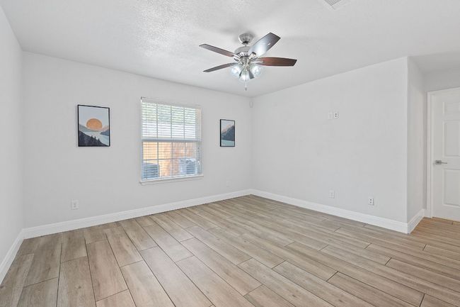 Spare room with light wood-style flooring, ceiling fan, and a textured ceiling | Image 11