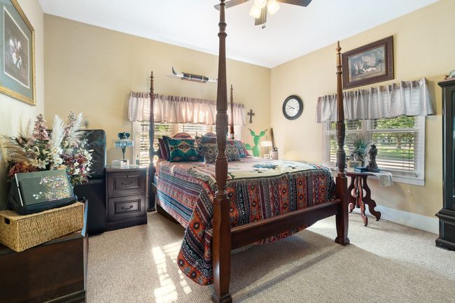 Bedroom featuring carpet floors, multiple windows, and ceiling fan | Image 21