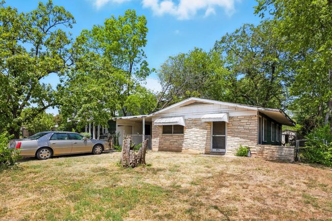 View of front facade featuring a front lawn, stone siding, and an attached carport | Image 4