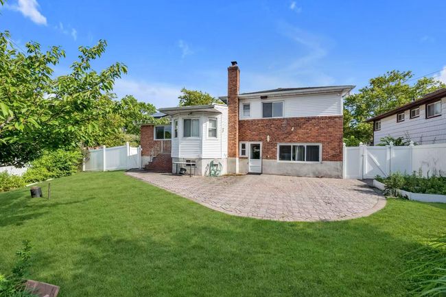 Back of property with a chimney, brick siding, a patio area, and a gate | Image 15