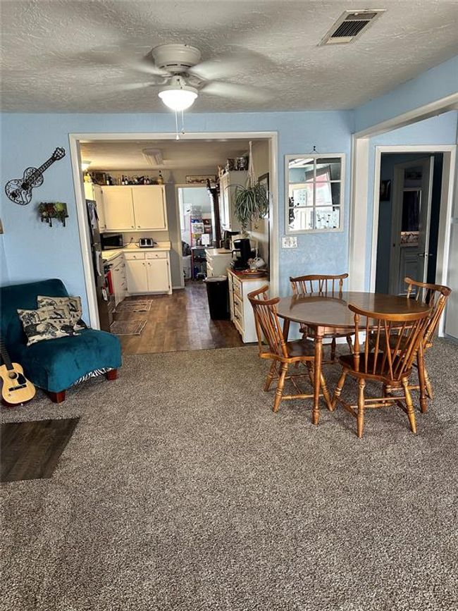 Dining space featuring ceiling fan, visible vents, dark wood-type flooring, and a textured ceiling | Image 4