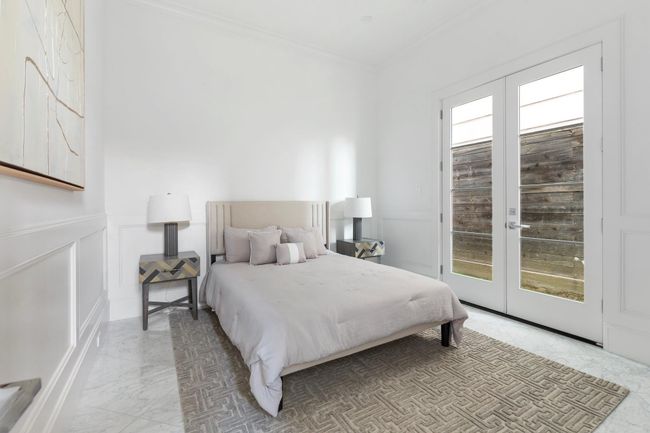 The ground floor bedroom has a large ensuite bathroom with attached closet and french door access to the back grassy area. | Image 40