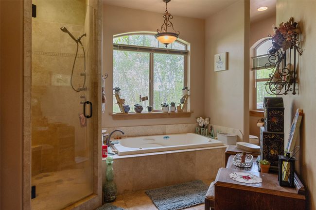 Bathroom featuring a stall shower, a garden tub, and tile patterned flooring | Image 35