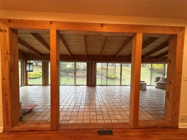 Doorway featuring visible vents, tile patterned floors, beam ceiling, and wood ceiling | Image 7