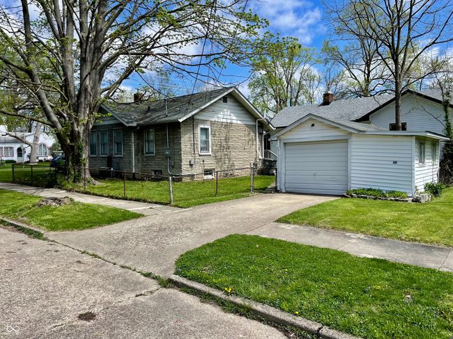 exterior space featuring a chimney, fence private yard, driveway, roof with shingles, and a lawn | Image 30