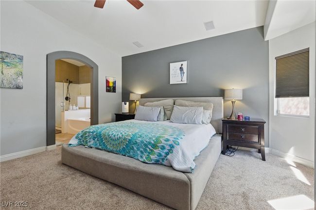 Bedroom with arched walkways, lofted ceiling, carpet floors, and baseboards | Image 17