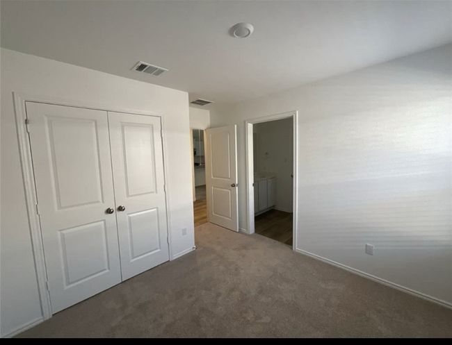 Unfurnished bedroom with carpet flooring, a closet, baseboards, and ensuite bathroom | Image 12