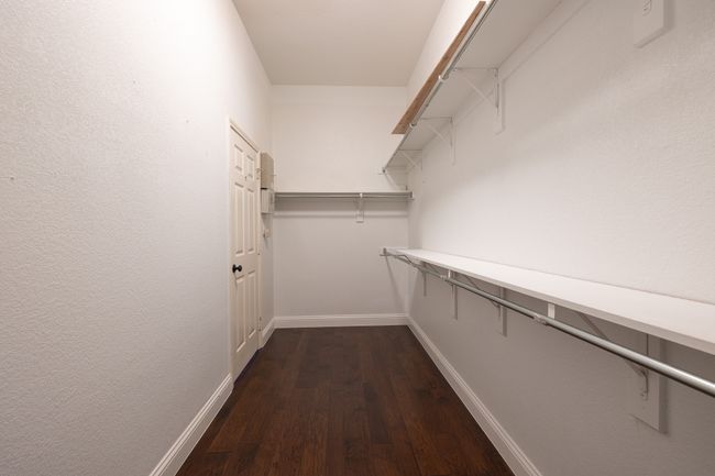 Walk in closet featuring dark wood-style flooring | Image 21