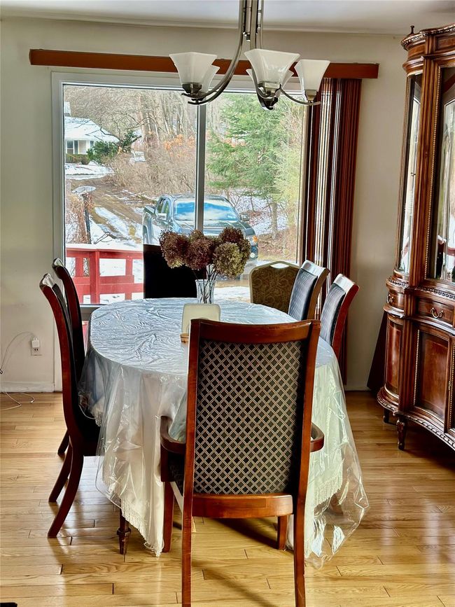 Dining area featuring light wood-type flooring and a notable chandelier | Image 12