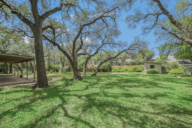 View of grassy yard featuring an outdoor structure and a storage unit | Image 16