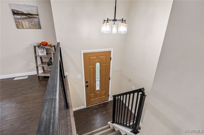 Foyer entrance featuring an inviting chandelier and dark hardwood / wood-style floors | Image 3