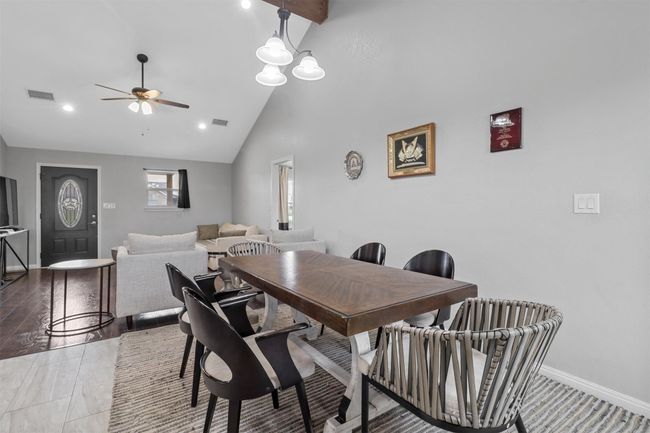 Dining room featuring a ceiling fan, high vaulted ceiling, baseboards, and visible vents | Image 11