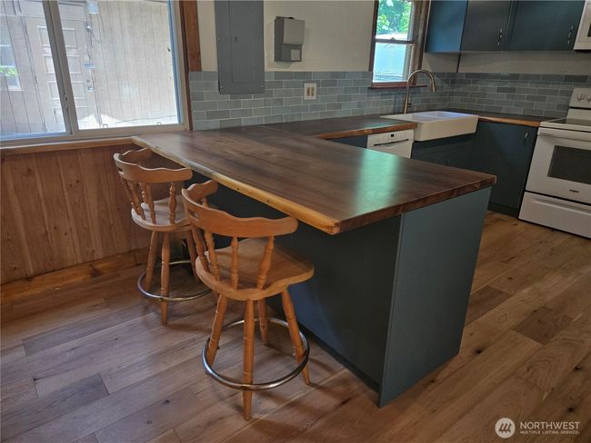 This large beautiful wood countertop serves as both great kitchen counter space as well as a convenient extra dining spot. | Image 9