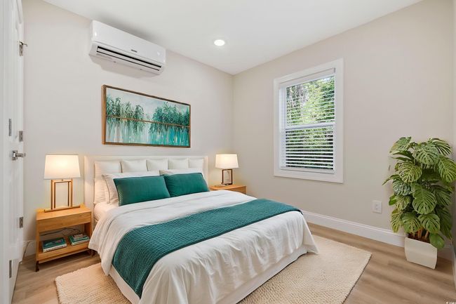 Bedroom with a wall mounted air conditioner, baseboards, light wood-style floors, and recessed lighting | Image 26