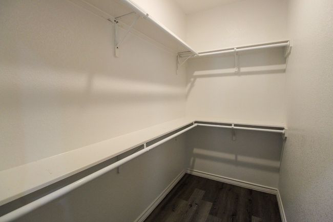 Spacious closet featuring dark wood-style floors | Image 13