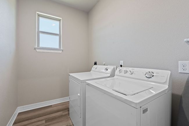 Laundry room featuring separate washer and dryer and wood finished floors | Image 29