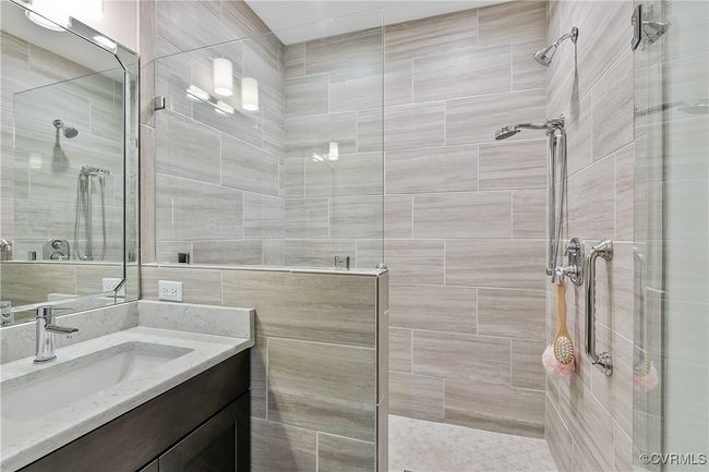 Bathroom featuring tiled shower and vanity | Image 25